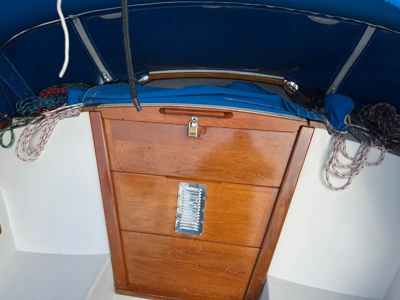 Wooden hatch on 1990 Catalina 30 MkII sailboat with ropes and blue cover.