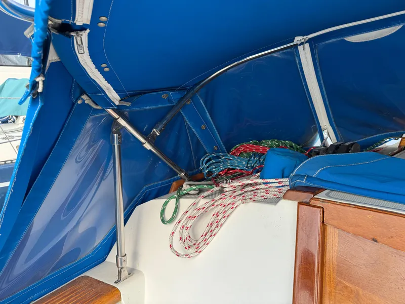 1990 Catalina 30 MkII sailboat cockpit with blue canopy and colorful ropes.