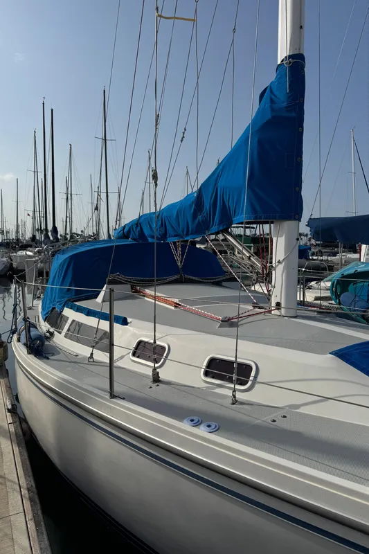 1990 Catalina 30 MkII sailboat docked with blue covers and rigging.