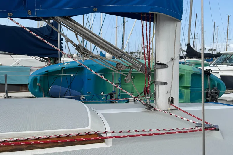 Catalina 30 MkII sailboat, 1990 model, docked with visible rigging and colorful kayaks in background.