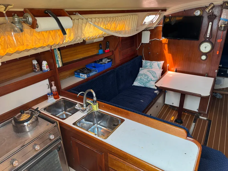 Interior of a 1990 Catalina 30 MkII sailboat with kitchen and seating area.
