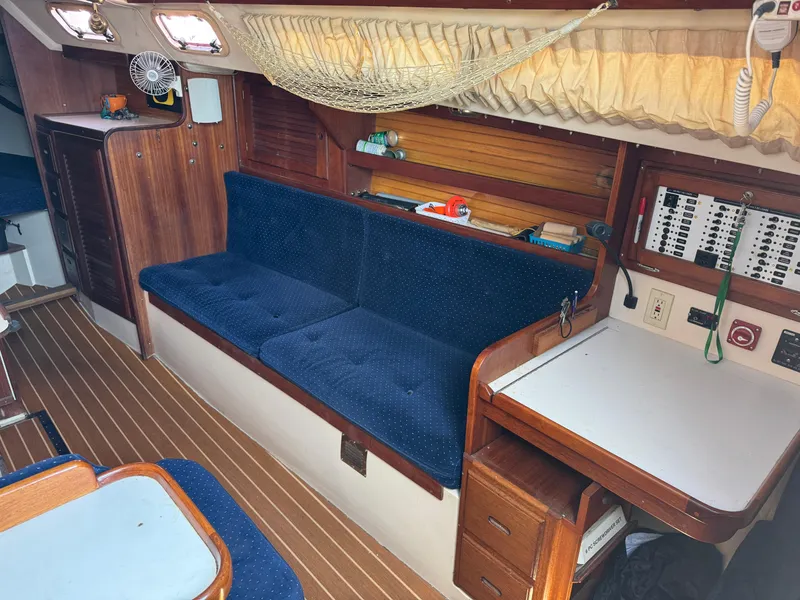 Interior of a 1990 Catalina 30 MkII sailboat with blue seating and wooden accents.