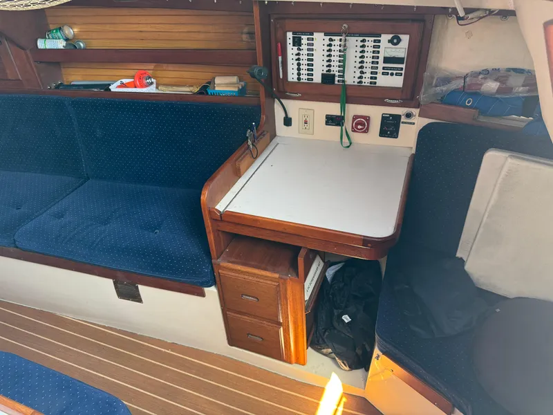 Interior of a 1990 Catalina 30 MkII sailboat with blue seating and navigation station.
