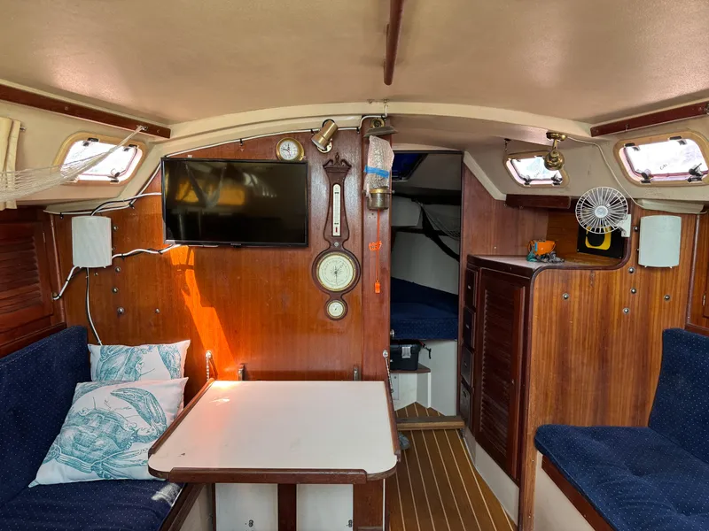 Interior of a 1990 Catalina 30 MkII sailboat with cozy seating and nautical decor.