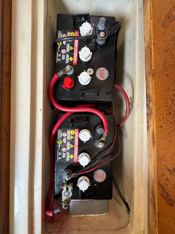 Two marine batteries in a Catalina 30 MkII, 1990 model, with red and black cables.