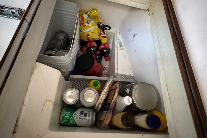 Storage compartment in a 1990 Catalina 30 MkII, filled with various food and drink items.