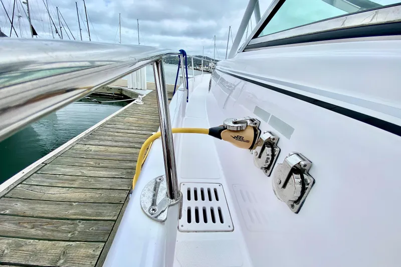 2006 Donzi 38 ZSF boat docked, showing power connections and sleek white exterior.