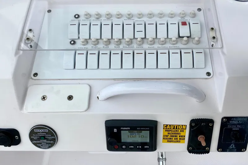 Control panel of a 2006 Donzi 38 ZSF boat with switches and caution label.