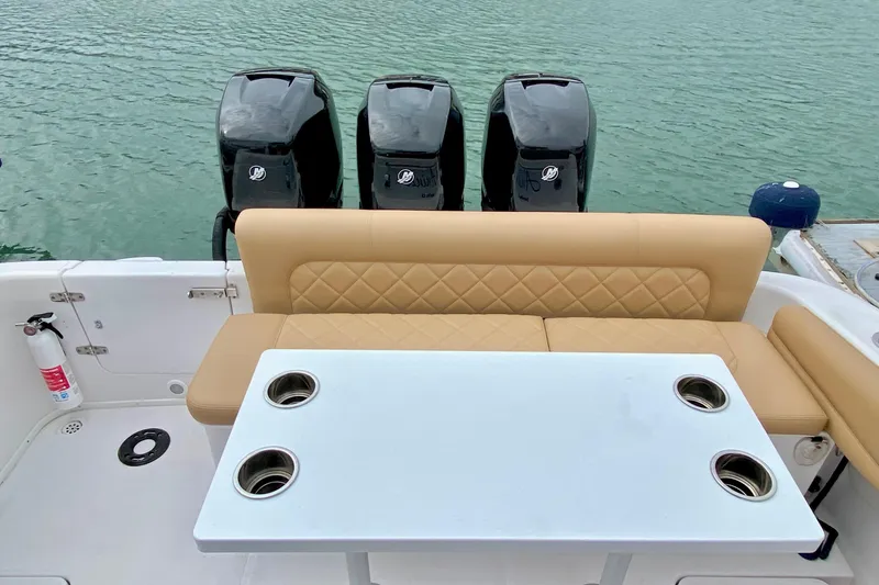 2006 Donzi 38 ZSF boat interior with seating, table, and triple outboard motors.