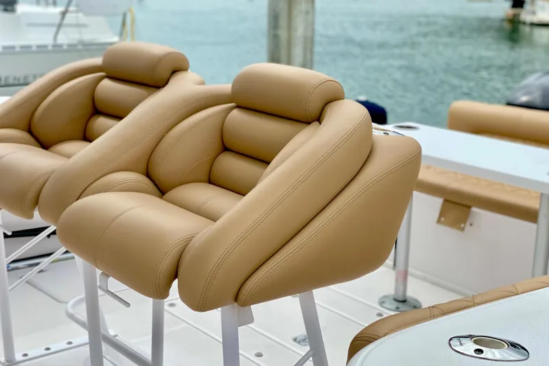 Luxurious tan leather seats on a 2006 Donzi 38 ZSF boat, docked by the water.