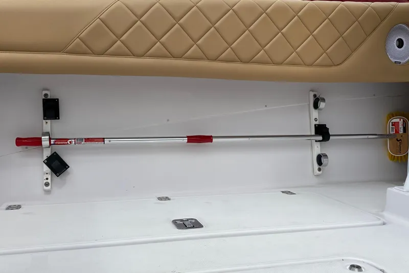 2006 Donzi 38 ZSF interior with beige quilted upholstery and mounted cleaning tools.