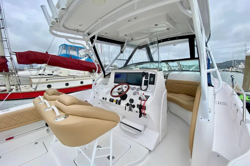 2006 Donzi 38 ZSF boat cockpit with beige seating and modern controls at a marina.