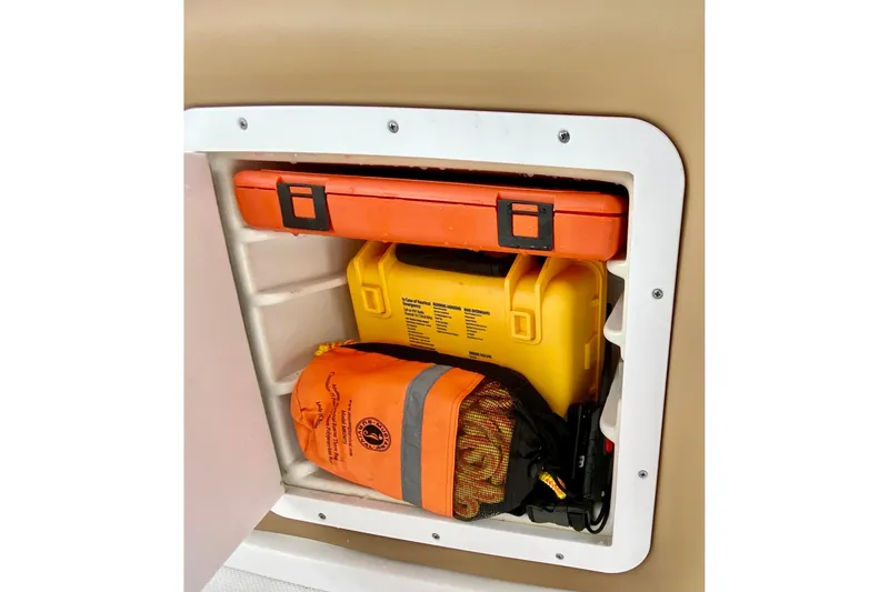 Storage compartment on a 2006 Donzi 38 ZSF boat with safety equipment.