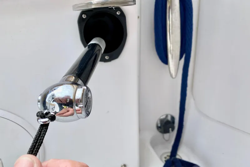 Close-up of a 2006 Donzi 38 ZSF boat's chrome shower handle and blue rope.