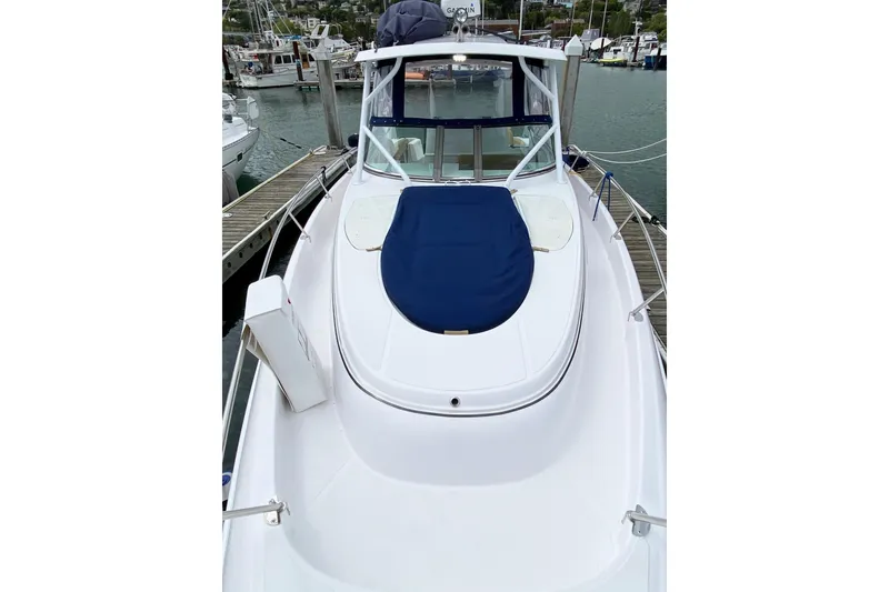 2006 Donzi 38 ZSF boat docked at marina, featuring sleek white design and blue cover.