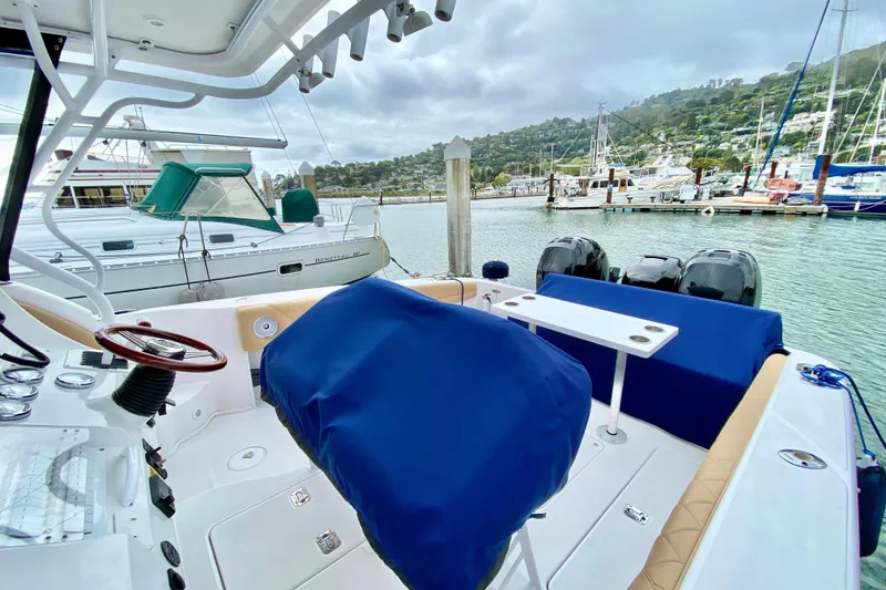 2006 Donzi 38 ZSF boat interior at marina, featuring blue covers and dual engines.