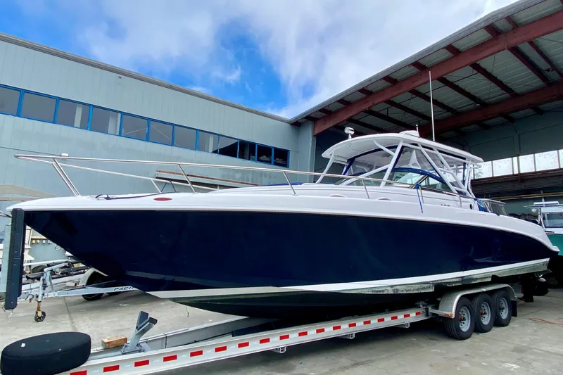 2006 Donzi 38 ZSF boat on trailer in marina, under blue sky.