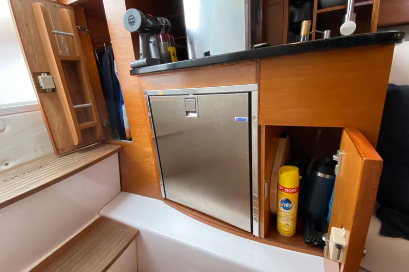 2006 Donzi 38 ZSF cabin interior with fridge and storage cabinets.