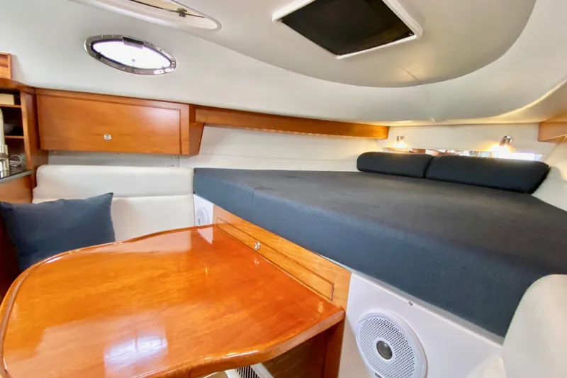 Interior cabin of a 2006 Donzi 38 ZSF boat with wood accents and cozy seating.