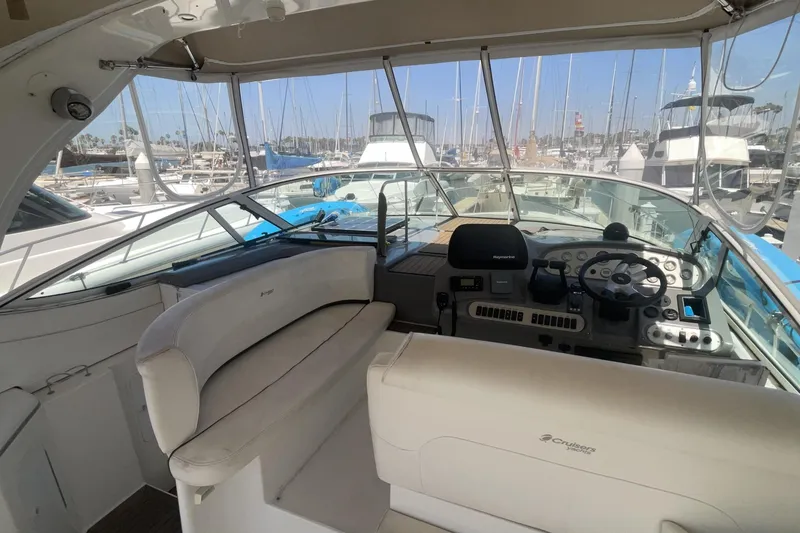 2006 Cruisers Yachts 370 Express cockpit with helm, marina view in background.