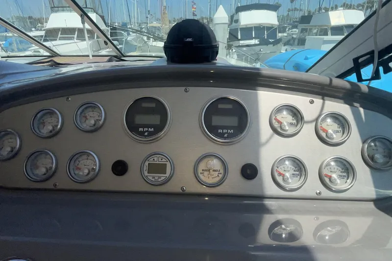 Dashboard of a 2006 Cruisers Yachts 370 Express with gauges and controls in a marina setting.