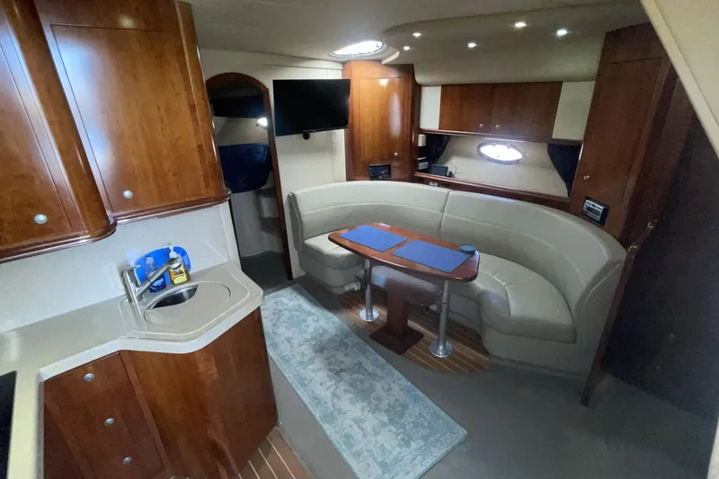 2006 Cruisers Yachts 370 Express interior with elegant wood cabinetry and cozy seating area.