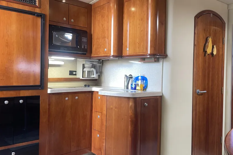 2006 Cruisers Yachts 370 Express interior kitchen with wooden cabinets and modern appliances.