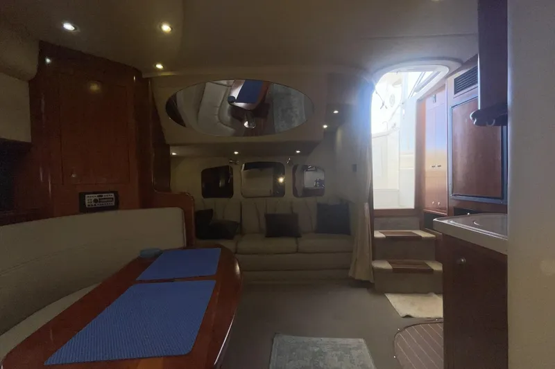 Interior of 2006 Cruisers Yachts 370 Express, featuring cozy seating and elegant wood finishes.