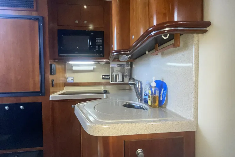 2006 Cruisers Yachts 370 Express kitchen with wood cabinetry and modern appliances.