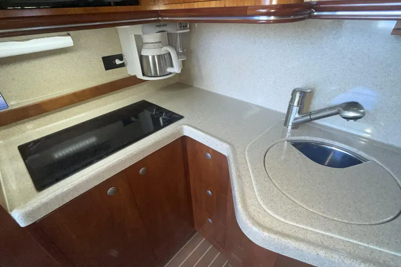 2006 Cruisers Yachts 370 Express galley with stove, sink, and coffee maker.