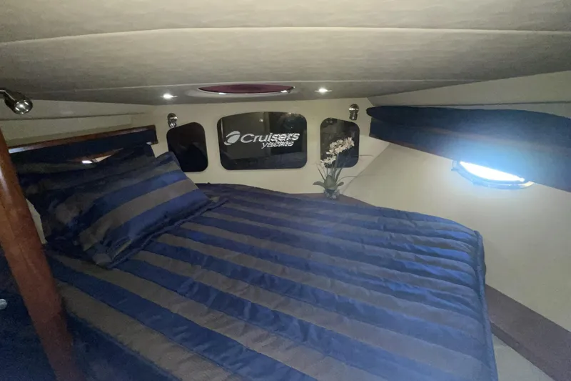 Luxurious cabin interior of 2006 Cruisers Yachts 370 Express with striped bedding.