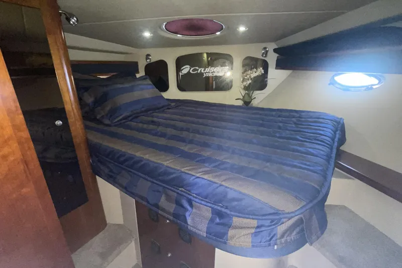 Luxurious cabin interior of 2006 Cruisers Yachts 370 Express with cozy bed and elegant decor.