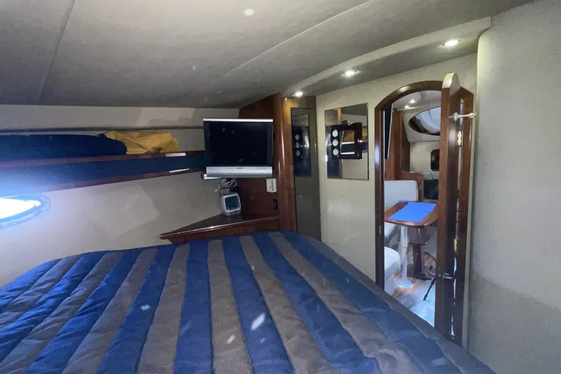 Interior cabin of 2006 Cruisers Yachts 370 Express with bed, TV, and seating area.