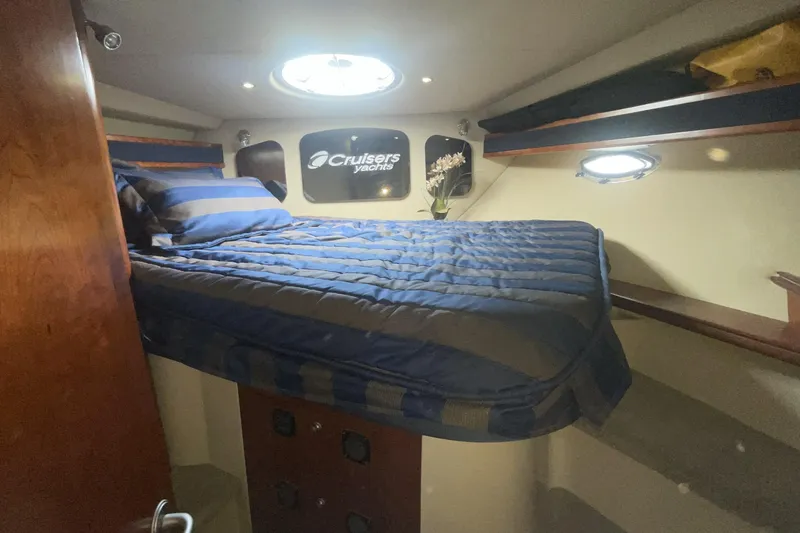 Interior cabin of 2006 Cruisers Yachts 370 Express with cozy bed and porthole.