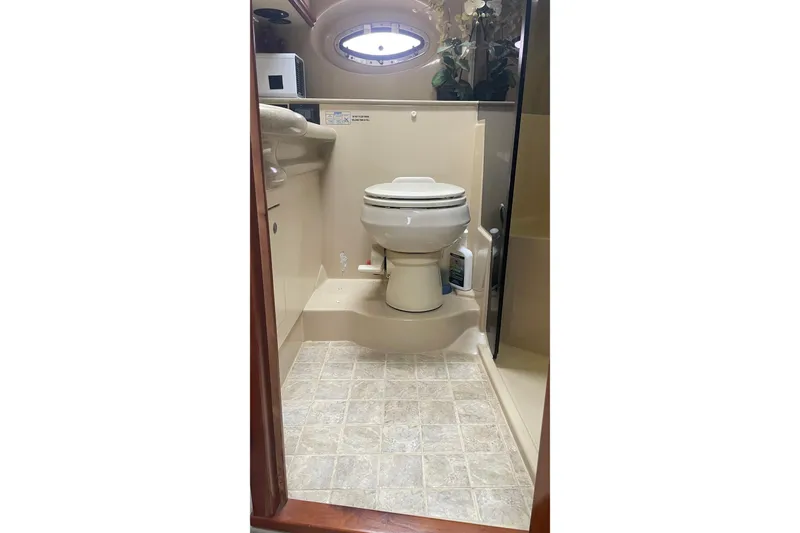 Bathroom interior of 2006 Cruisers Yachts 370 Express with toilet and porthole window.