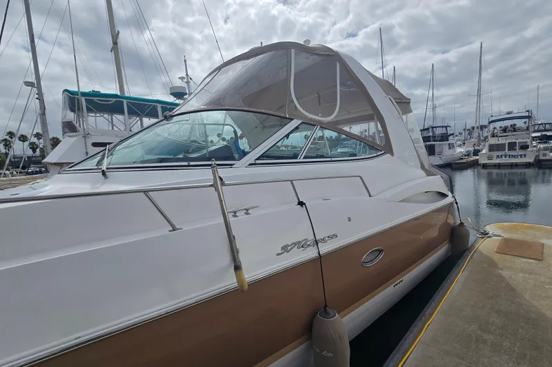 2006 Cruisers Yachts 370 Express docked at marina under cloudy sky.