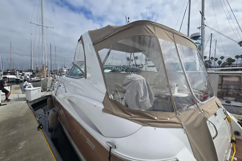 2006 Cruisers Yachts 370 Express docked at marina, featuring beige canopy and sleek design.