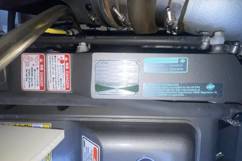 Engine compartment of a 2006 Cruisers Yachts 370 Express with warning labels and specifications.