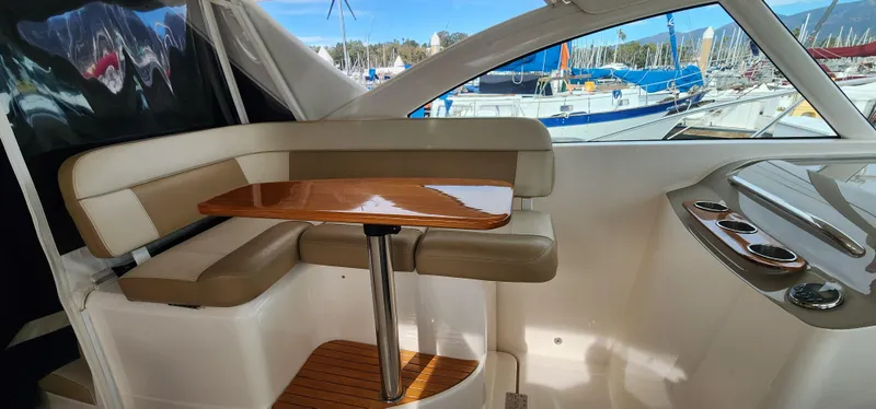 2012 Tiara Yachts 3100 Coronet interior with seating and table, docked at marina.