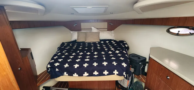 2012 Tiara Yachts 3100 Coronet cabin with bed, wood accents, and storage.