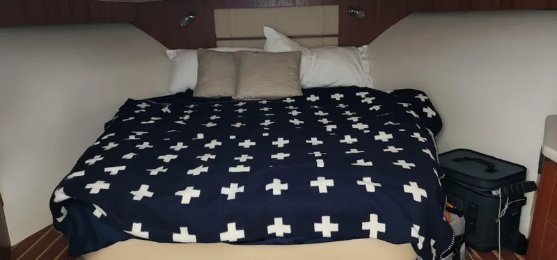 Cozy cabin interior of 2012 Tiara Yachts 3100 Coronet with patterned bedding.