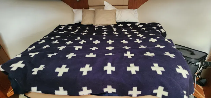 Cozy bed with cross-patterned blanket in 2012 Tiara Yachts 3100 Coronet cabin.