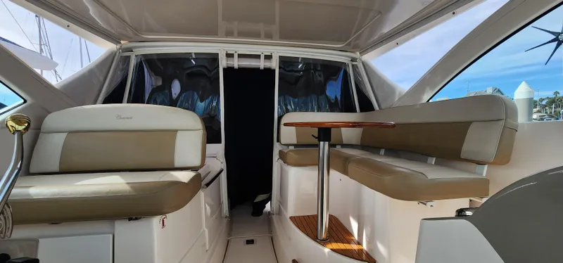 Interior of 2012 Tiara Yachts 3100 Coronet with beige seating and wooden table.