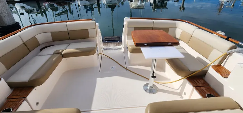 2012 Tiara Yachts 3100 Coronet interior with beige seating and wooden table.