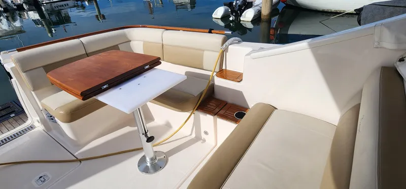 2012 Tiara Yachts 3100 Coronet interior with seating and table, docked at marina.