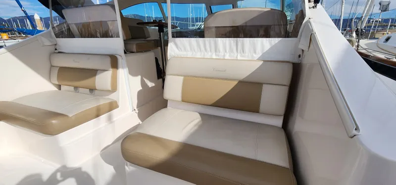 2012 Tiara Yachts 3100 Coronet interior with beige and white seating, docked at marina.