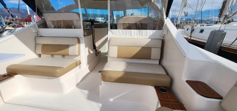 2012 Tiara Yachts 3100 Coronet interior with beige seating and wooden accents.
