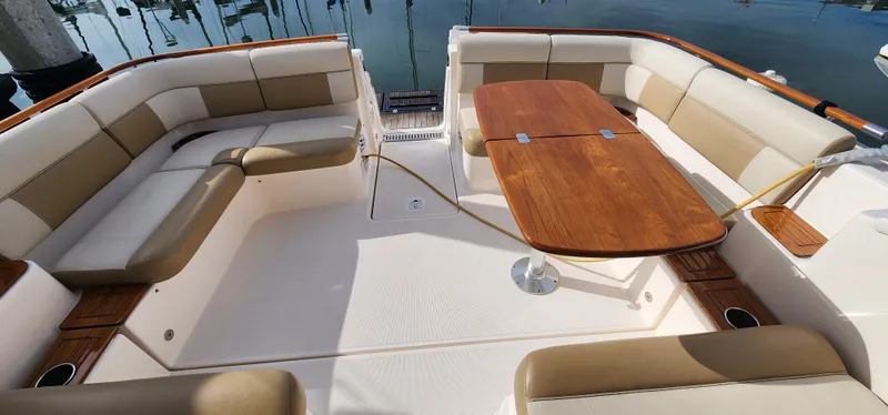 2012 Tiara Yachts 3100 Coronet interior with beige seating and wooden table.