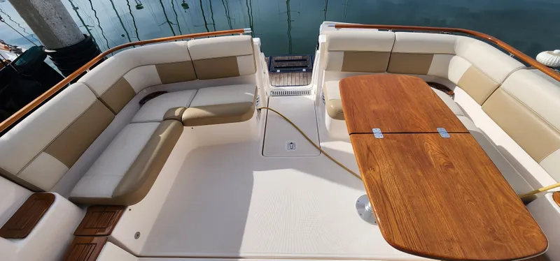 Luxurious seating area on a 2012 Tiara Yachts 3100 Coronet with wooden table.