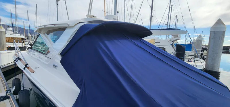 2012 Tiara Yachts 3100 Coronet with blue cover docked at marina.